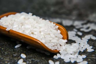 Riz cuit dans un bol avec des légumes colorés à côté