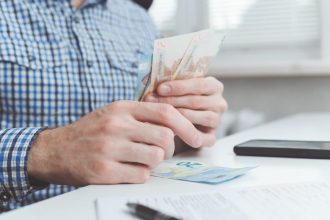 Professionnel calculant les coûts liés au portage salarial dans un bureau