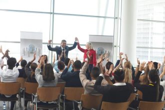 Groupe diversifié applaudissant lors d'un séminaire d'entreprise dynamique