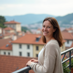 Femme souriante regardant la ville européenne depuis un balcon