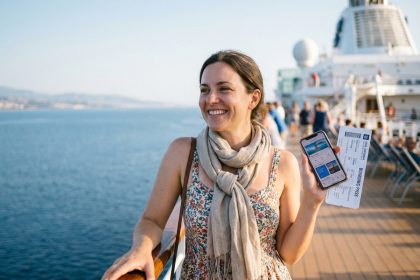 Femme souriante avec ticket de croisiere et smartphone
