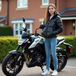 Jeune femme avec moto 125cc devant maison résidentielle