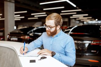 Homme achetant une voiture dans une concession automobile