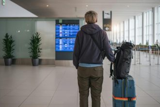 Homme asiatique attendant à l'aéroport international avec impatience